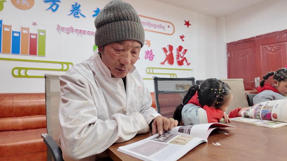 一位當地村民和孩子們在牧家書屋裡盡情享受閱讀時光。申扎縣融媒體中心供圖