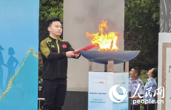 在活动开幕式上，冯喆点燃火炬。人民网记者 杨磊摄