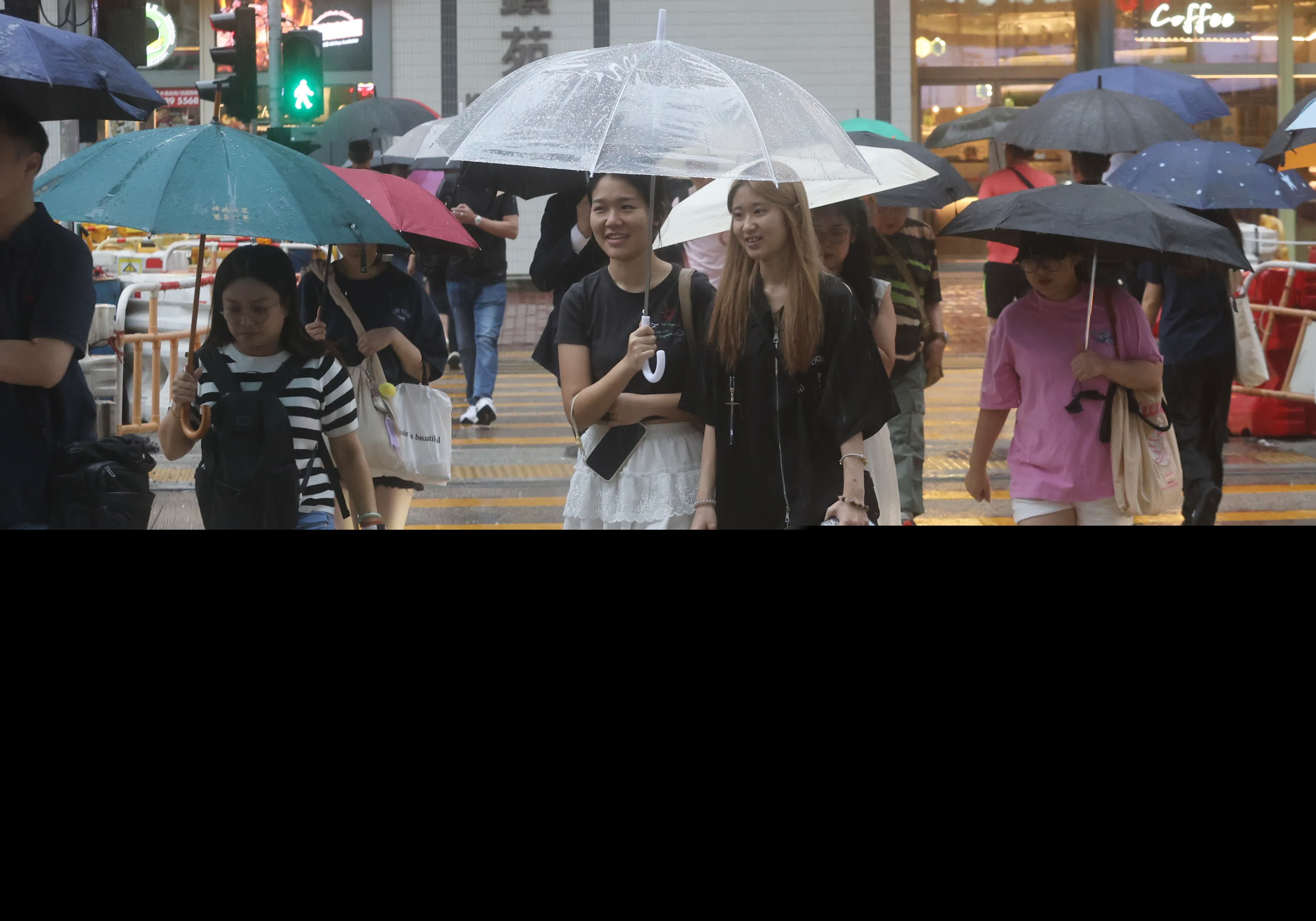 市民在黑雨警告信號下冒雨出行。（香港文匯報記者郭木又攝）