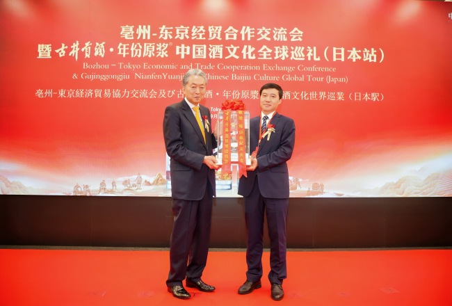 图丨亳州市委常委、副市长钟治峰向鸠山由纪夫先生赠送年份原浆纪念酒