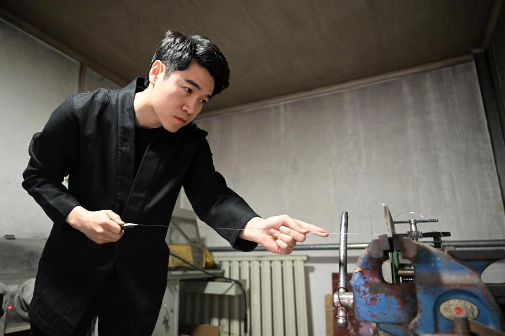 马赛在工作室内进行手工拔丝。新华社发